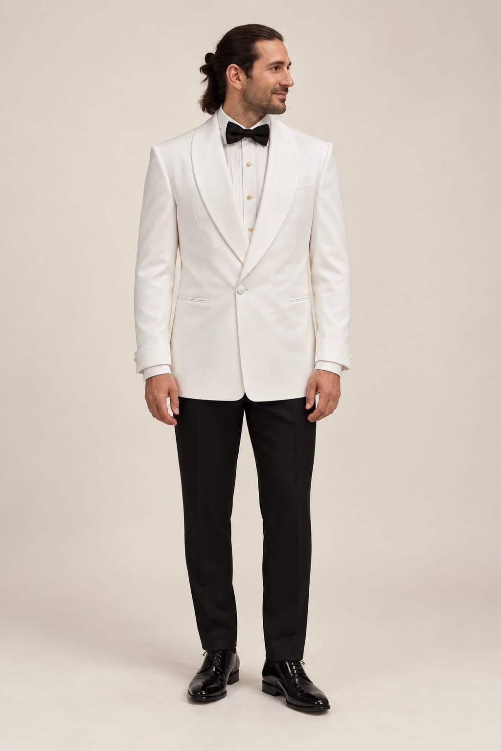 Model wearing the white shawl-lapel tuxedo jacket with black trousers and bow tie, full length