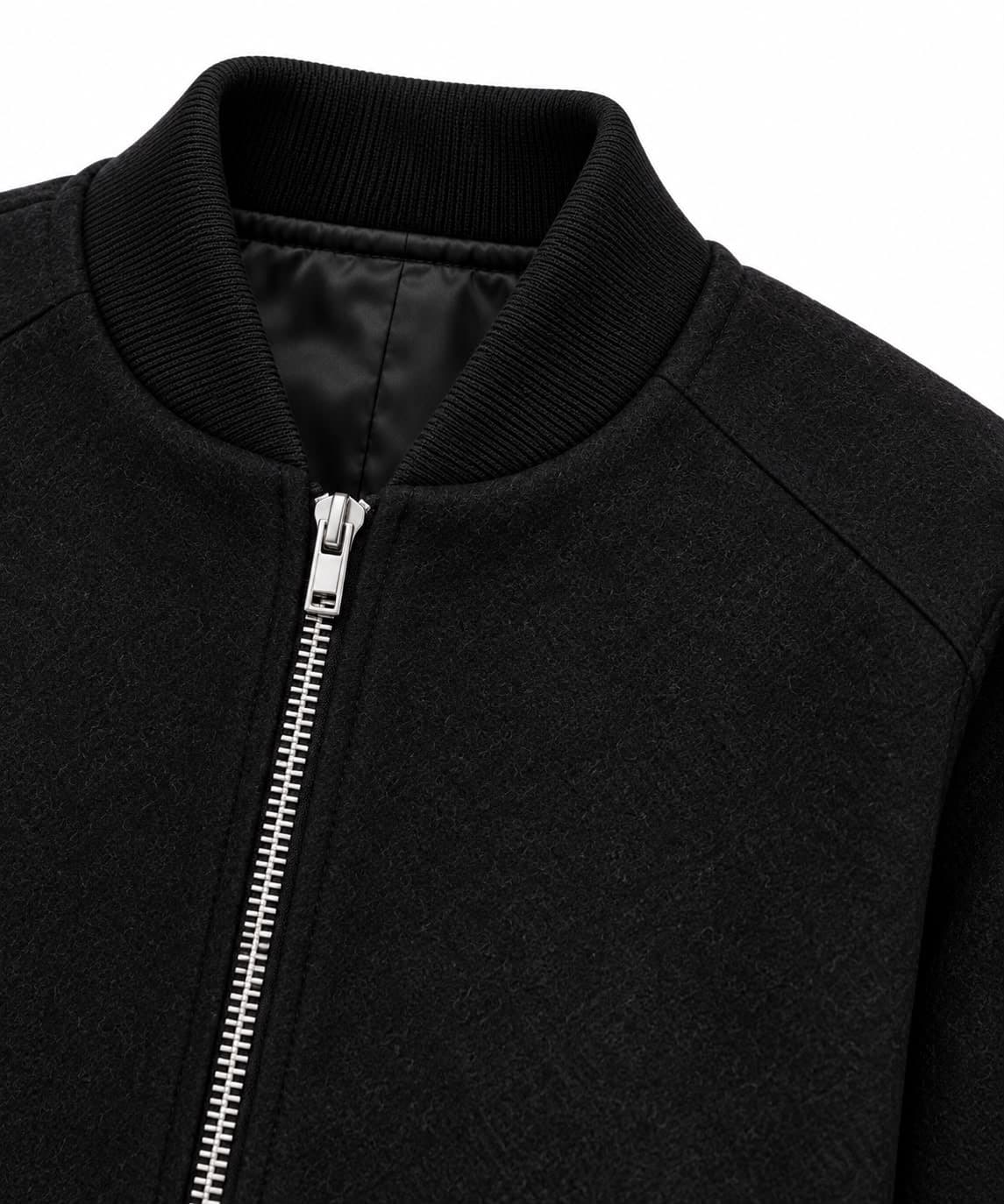 Close-up of the ribbed stand collar, silver zip and satin lining of the black wool bomber jacket