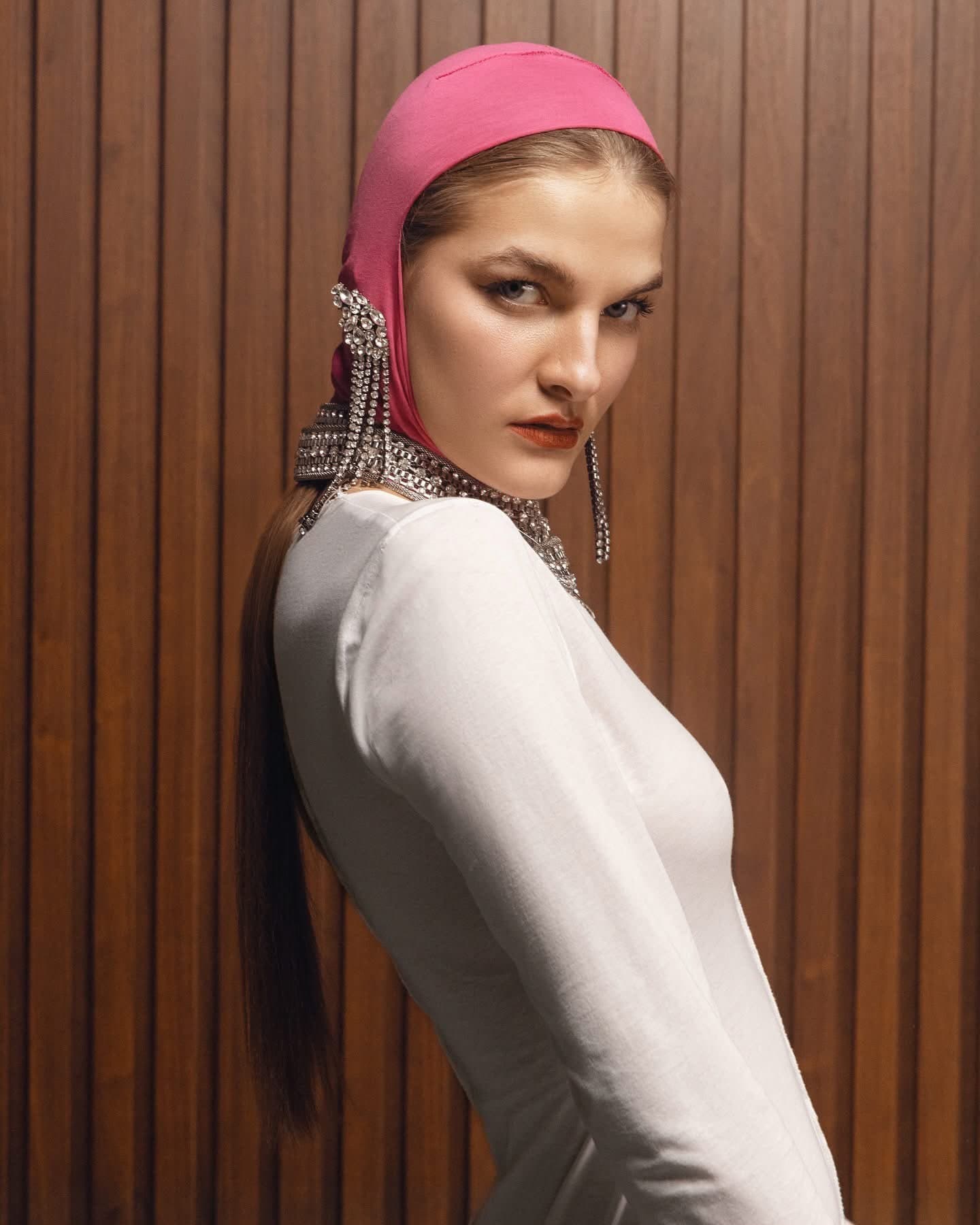 Model in the ivory ribbed gown, side view, against a walnut slatted wall