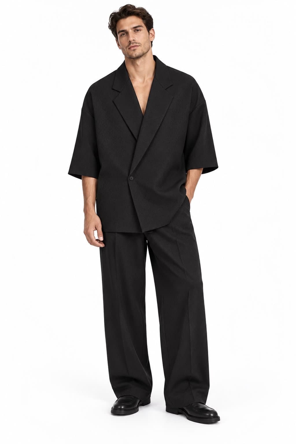 Model wearing the black oversized short-sleeve suit jacket and wide-leg trousers