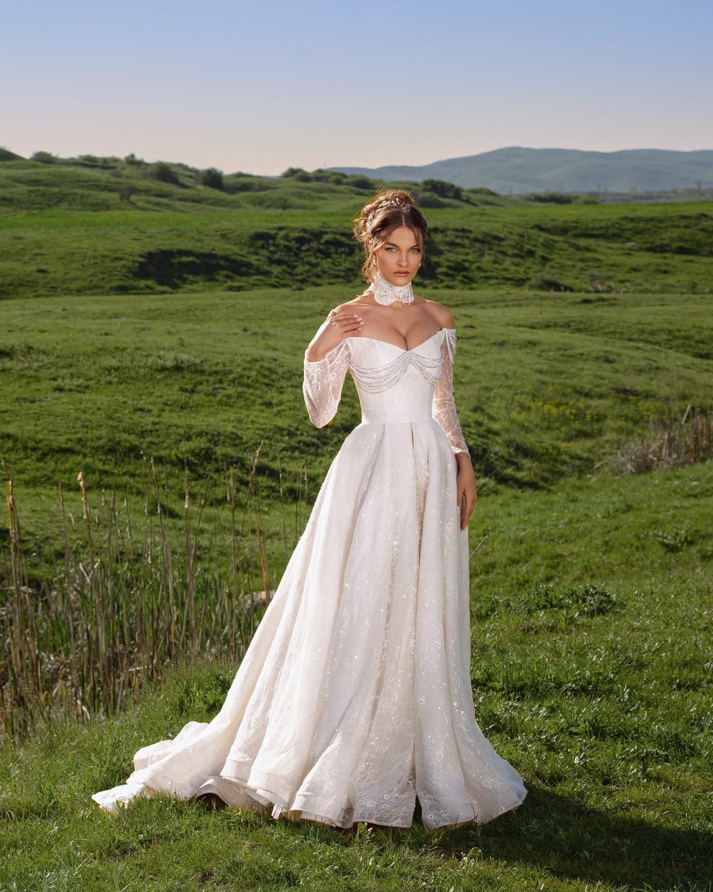 Bride in the Manches Illusion Gown, full length, hand at the collar