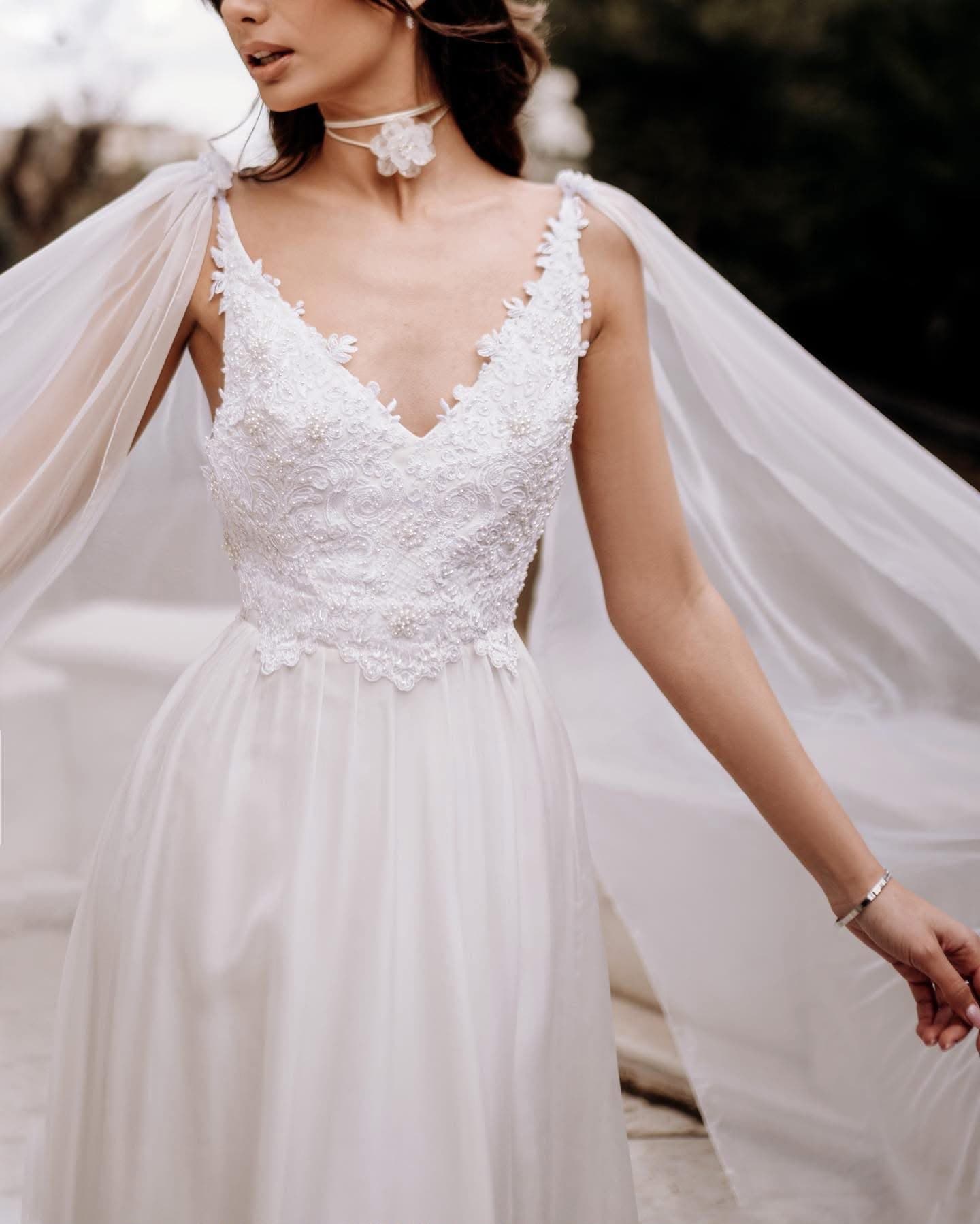 Close view of the floral lace bodice and tulle cape of the Cape Fleurie Gown