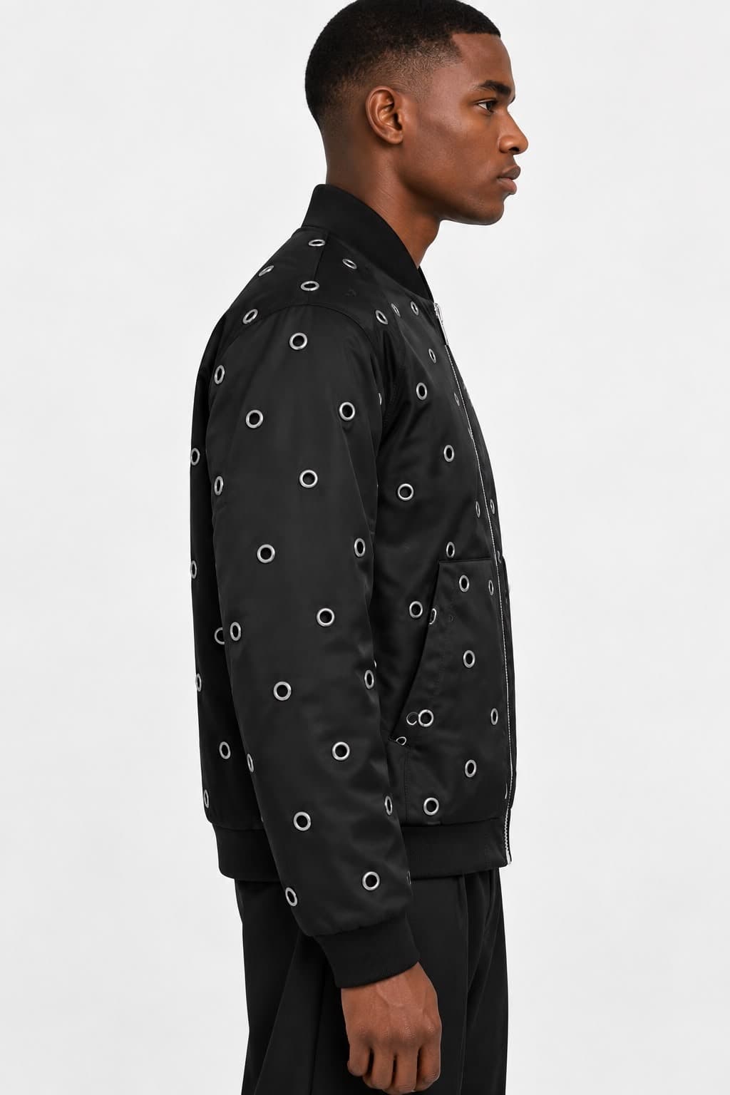 Model in the black eyelet bomber jacket, three-quarter view from the side