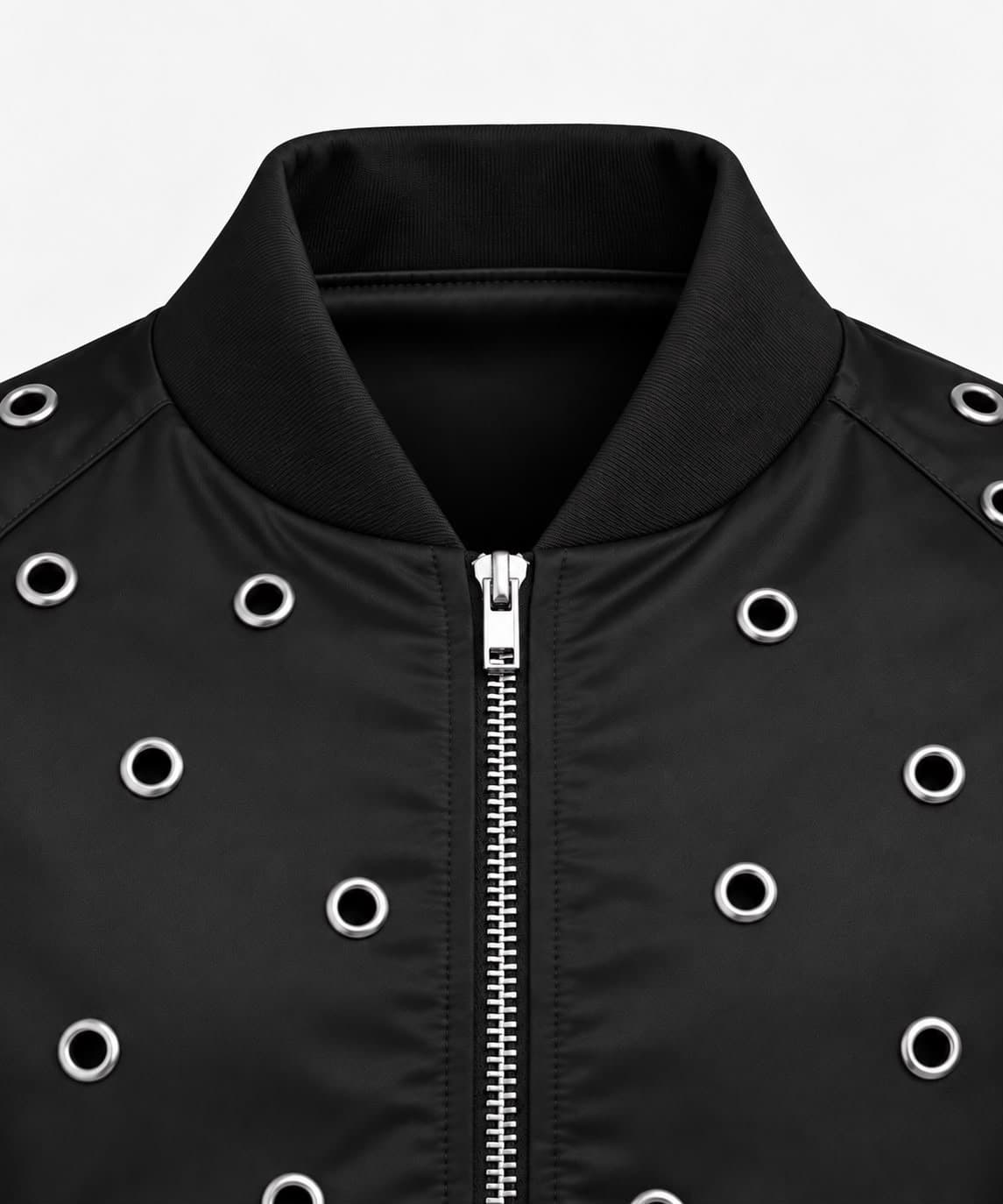 Close-up of the ribbed stand collar and silver zip of the black eyelet bomber jacket